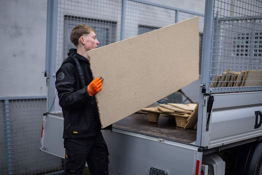 De rommelophaaldienst van Damagmee laadt oude spullen en afval in de werkbus
